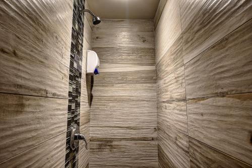 a bathroom with a shower with wooden walls at Hotel et Motel Le Chateauguay in Quebec City