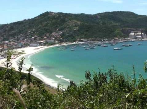 アハイアウ・ド・カボにあるÓtima Suíte próximo a Praia dos Anjosの海上のボートが乗るビーチの景色