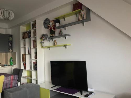 a living room with a flat screen tv on a wall at Apartman Biblioteka Čardaka 10/61 in Kopaonik