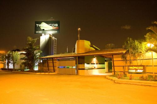 a building with a sign on top of it at night at Trópicos Motel in Natal