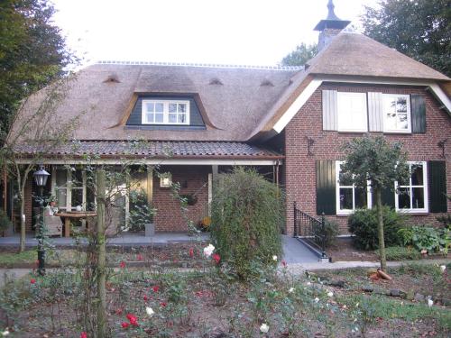 a brick house with a thatched roof at B&B De Zeven Berken in Nistelrode