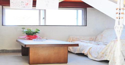 a bedroom with a bed and a table and windows at Hoshi sunasou / Vacation STAY 9250 in Furusato