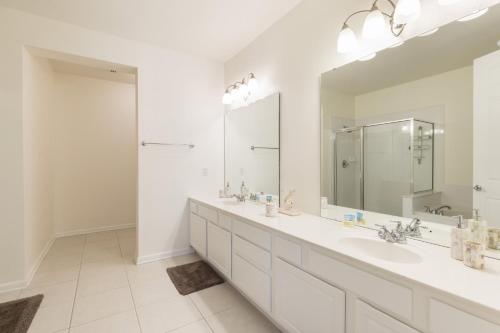 a bathroom with two sinks and a large mirror at Wonderful Vacation Apartment with Balcony at Vista Cay VC5025-103 in Orlando