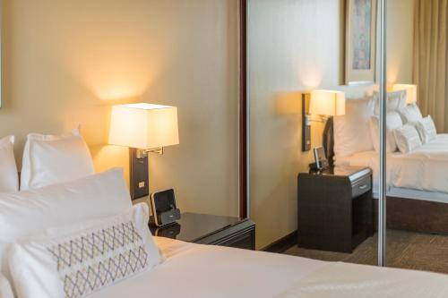 a hotel room with a bed and a mirror at Delfines Hotel & Convention Center in Lima