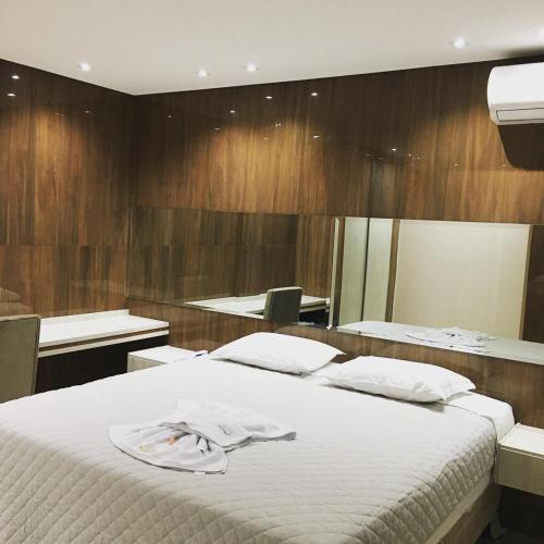 a bedroom with a large bed and a mirror at Prudentópolis Palace Hotel in Prudentópolis