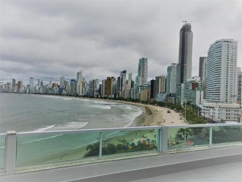 a view of a beach and a city with tall buildings at Apartamento Studio Superior com vista da BIG Wheel in Balneário Camboriú