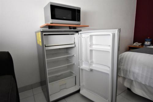 a white refrigerator with a microwave on top of it at Hotel México Inn Express in Salamanca