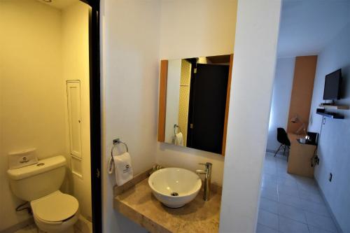 a bathroom with a toilet and a sink at Hotel México Inn Express in Salamanca