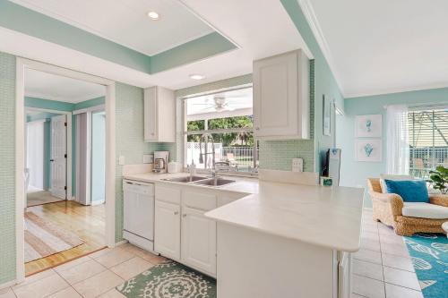 a kitchen with white cabinets and a large window at Comfortably Chic Pool Home Retreat in Naples