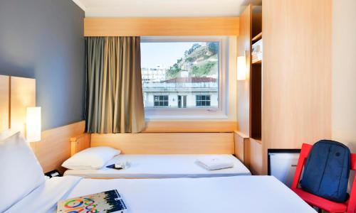 una camera d'albergo con due letti e una finestra di ibis Copacabana Posto 5 a Rio de Janeiro