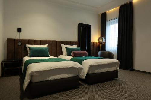 a hotel room with two beds and a window at Hotel Rubis in Ferizaj