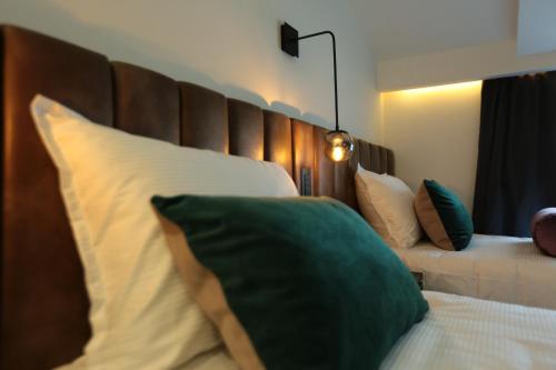 a bedroom with a bed with a large wooden headboard at Hotel Rubis in Ferizaj