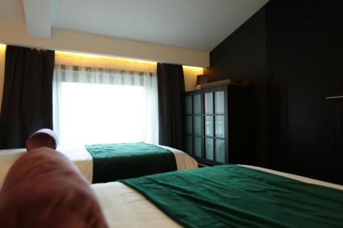 a room with two beds and a window at Hotel Rubis in Ferizaj