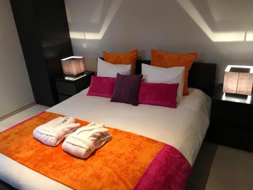 una camera da letto con un grande letto con asciugamani di B&B L'Orangerie a Waterloo
