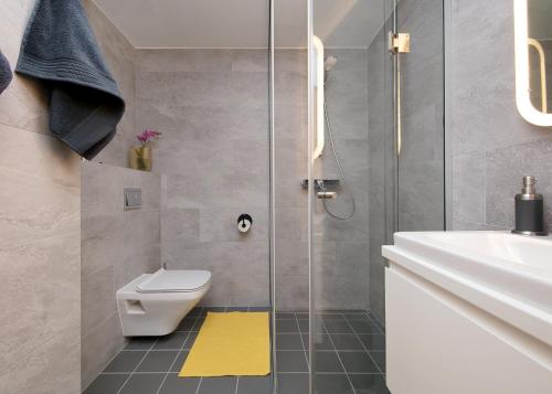 a bathroom with a shower and a toilet and a sink at TP City Apartment - City Center in Tallinn
