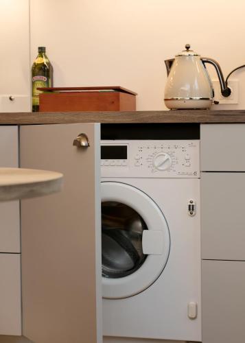 a washing machine with a tea kettle on top of it at TP City Apartment - City Center in Tallinn