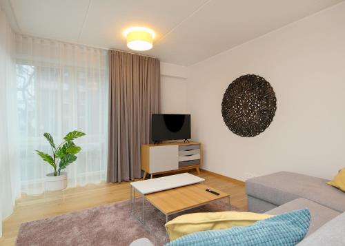 a living room with a couch and a tv at TP City Apartment - City Center in Tallinn