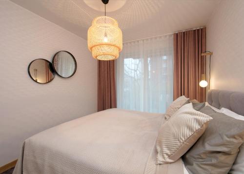 a bedroom with a white bed and a chandelier at TP City Apartment - City Center in Tallinn