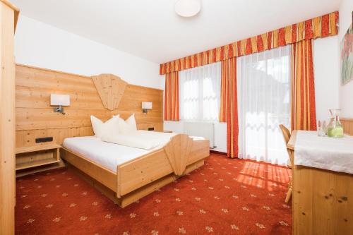 a bedroom with a bed and a large window at Landhaus Pfurtscheller in Neustift im Stubaital