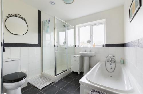 a white bathroom with a toilet and a sink at The Hideaway in Stratford-upon-Avon