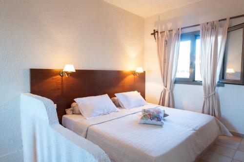 a bedroom with a large bed with a wooden headboard at Porto Sisi Hotel Apartments in Sissi