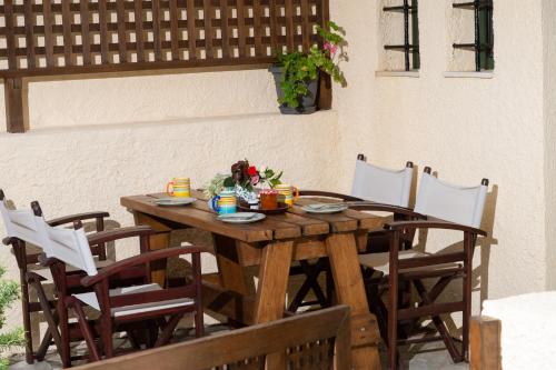 a wooden table and chairs on a patio at Porto Sisi Hotel Apartments in Sissi