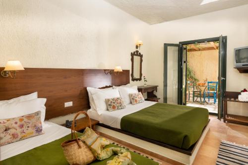 a hotel room with two beds and a television at Porto Sisi Hotel Apartments in Sissi