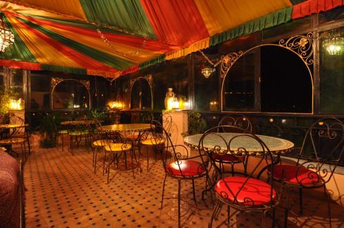 una habitación con mesas y sillas en un restaurante en Riad Khouloud, en Fez