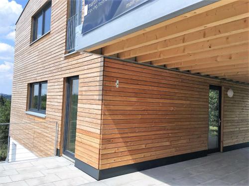 a building with a wooden facade with windows at Ferienwohnungen Weinstadt in Weinstadt