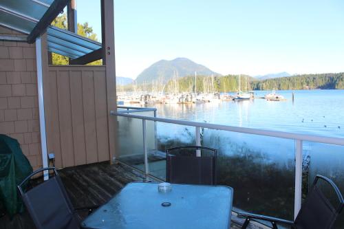a porch with a view of a marina with boats at Siennas Harbour House in Tofino