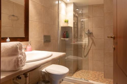 a bathroom with a shower and a toilet and a sink at Porto Sisi Hotel Apartments in Sissi