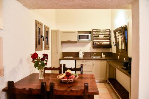 a kitchen with a table with a bowl of fruit on it at Porto Sisi Hotel Apartments in Sissi