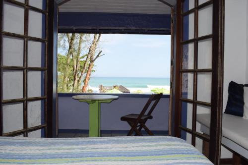 1 dormitorio con cama y vistas al océano en Casa da Ruth Pousada, en Búzios