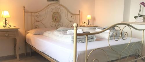 a bedroom with a bed with white blankets and pillows at La casa nel bosco in Malcesine