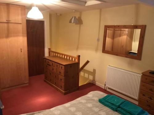 - une chambre avec un lit, une commode et un miroir dans l'établissement Tylwyth, à Waenfawr