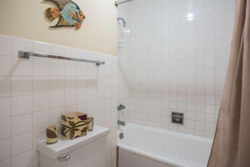 a bathroom with a toilet and a bath tub and a shower at Sunset Two Bedroom Suite At Turtle Towers in Ocho Rios