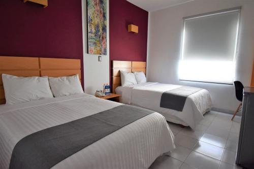 a hotel room with two beds and a window at Hotel México Inn Express in Salamanca