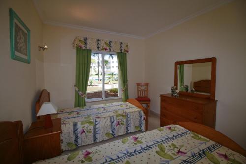 アルヴォルにあるAlvor Vila da Praia Pool & Garden Viewのベッドルーム1室(ベッド2台、ドレッサー、鏡付)
