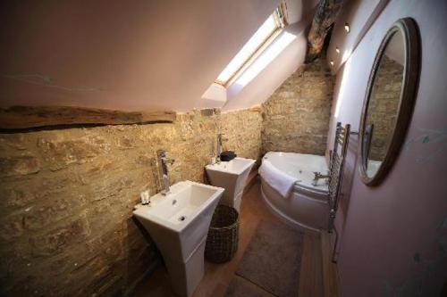 uma casa de banho com um lavatório, um WC e um espelho. em The Rake Tapas Accommodation em Littleborough