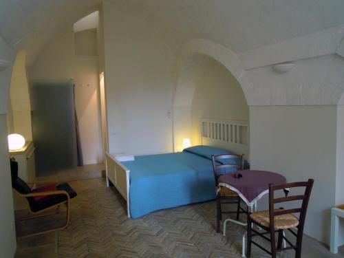 マテーラにあるB&b Il Cortileのベッドルーム1室(青いベッド1台、椅子2脚付)