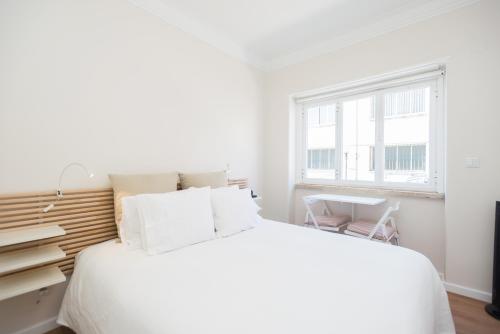 リスボンにあるRiverside Charming Studio in Belémの白いベッドルーム(大型ベッド1台、窓付)