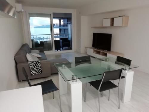 uma sala de estar com uma mesa de vidro e um sofá em Passeig del Mar, 2 em Palamós