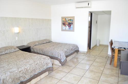 a hotel room with two beds and a tiled floor at Eco Bay Hotel in Bahía Kino