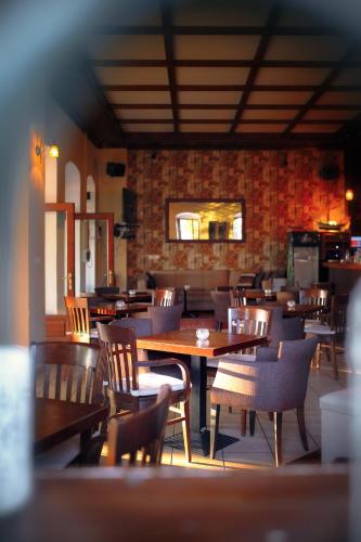 una sala da pranzo con tavoli e sedie in legno di Naftilos Guest House a Kala Nera