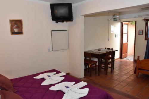 a room with a bed and a table with a tv at Residencial El Hogar in Salta