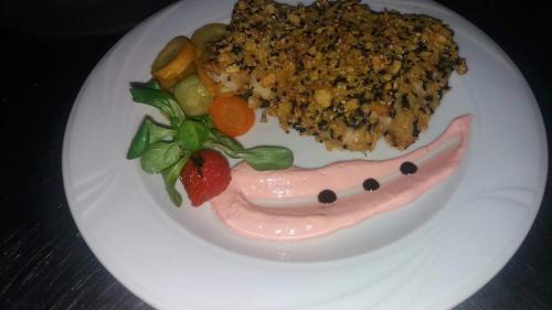 a plate of food with meat and vegetables on it at Hotel Dobru in Slănic-Moldova