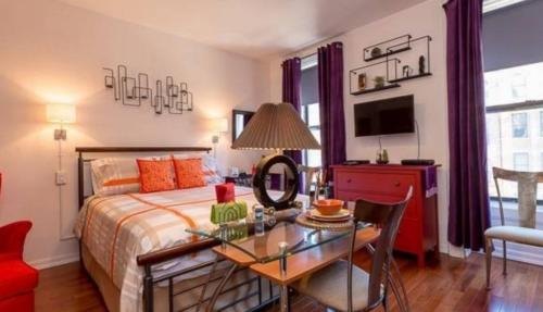 Un dormitorio con una cama y una mesa con una mesa. en Fabulous Fully Furnished Studio Minutes From Times Square! en Nueva York