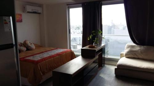 1 dormitorio con cama, sofá y ventana en Mirador 1205 en Buenos Aires