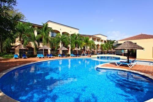 a large blue swimming pool with chairs and umbrellas at Sandos Playacar All Inclusive in Playa del Carmen