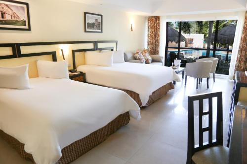 a hotel room with two beds and two lamps at Sandos Playacar All Inclusive in Playa del Carmen